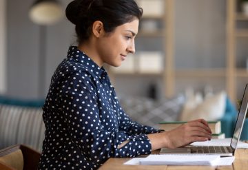 Indian girl using laptop studying