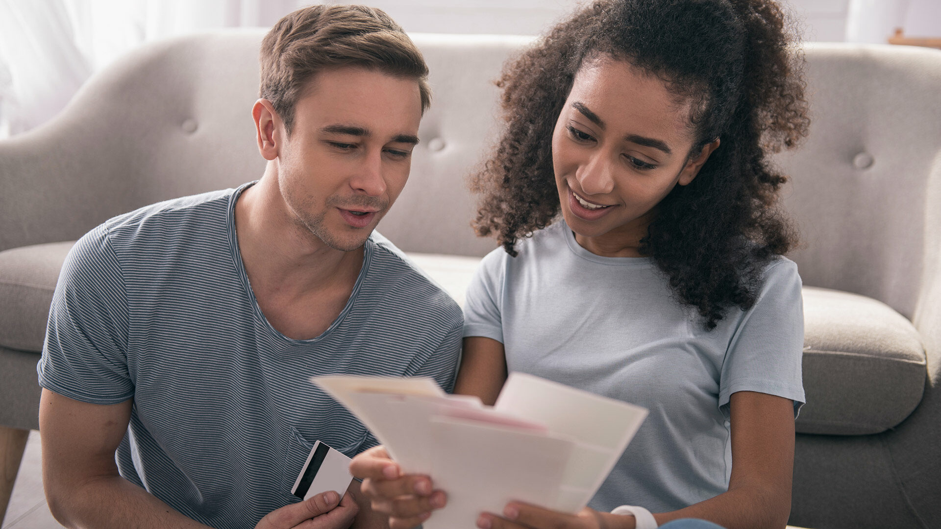 couple on sofa looking over finances